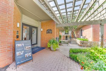 A brick building with a glass roof and a sign in front.